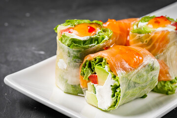 appetizing spring rolls with sea food and philadelphia cheese on a darck background