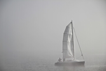 Unidentifiable man on the Boat in the mist and fog on the lake, 