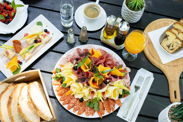 details of delicious outdoor brunch on black wooden table