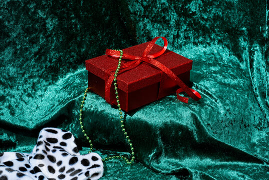 red gift box on a green velvety fabric