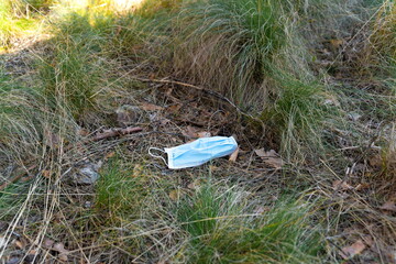 Surgical mask lying on the ground in the grass