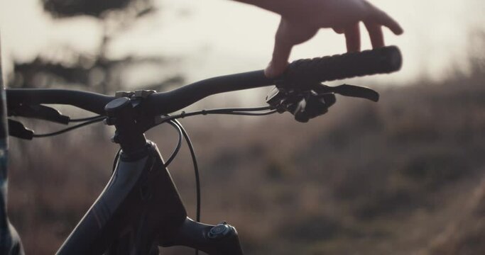 Man hold grab mtb bicycle bike handlebar wth hand close up lens flare