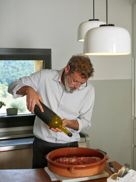 Cook preparing meat.