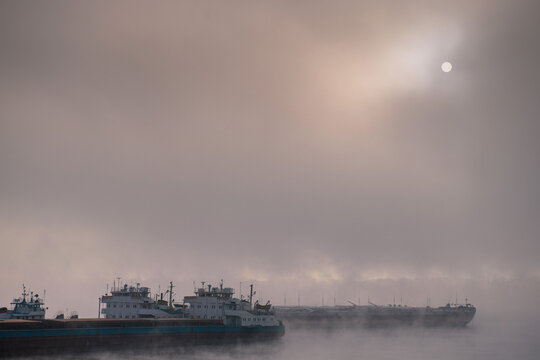 Empty cargo ships covered with fog in the shipyard