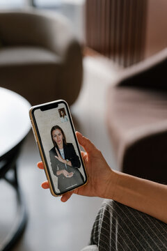 Crop woman watching friend waving hand during video call