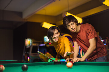 Young couple spending time in billiard room. Good shot.