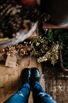 feet/ shoes with dried flowers on the floor