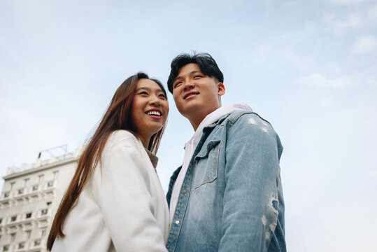 Portrait of Chinese couple posing over light blue sky
