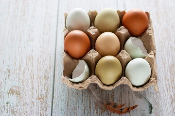 Organic eggs in a paper box on blue old wooden backround.