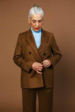 Senior female model buttoning elegant jacket