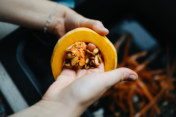 Person peeling pumpkin in the sink