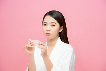 Young asian skin care woman upset after use oil blotting paper on her face