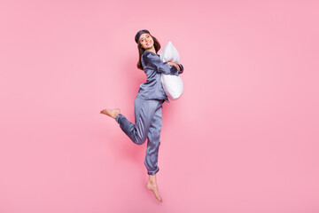 Full length body size photo of girl wearing pajama hugging embracing pillow jumping isolated on...
