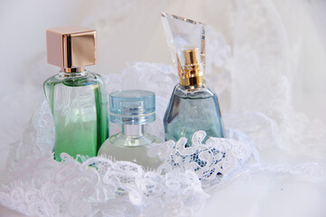 Obraz na płótnie Canvas perfume bottles or eau de toilette on a white background with lace