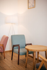 a coffee table and armchair has wooden leg. this place is a modern cafe.