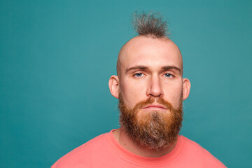 Bearded european man in casual peach isolated on turquoise background with gloomy expression needs...