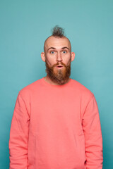 Obraz premium Bearded european man in casual peach isolated on turquoise background shocked with surprise expression, fear and excited face