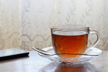 Tea in a transparent cup on a saucer.