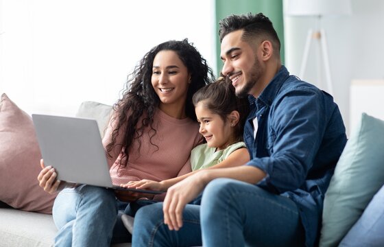 Happy Middle Eastern Family Of Three Using Laptop Together At Home