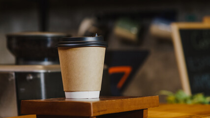 Take away hot coffee paper cup to consumer standing behind bar counter at cafe restaurant. Owner small business, food and drink, service mind concept.