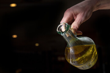Un uomo versa dell'olio da un oliera in un piatto