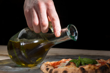 Un uomo versa dell'olio da un oliera in un piatto