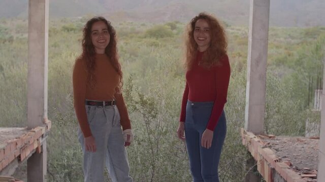 Hermanas gemelas sonriendo mostrando amistad, felicidad y complicidad en un d&iacute;a nublado