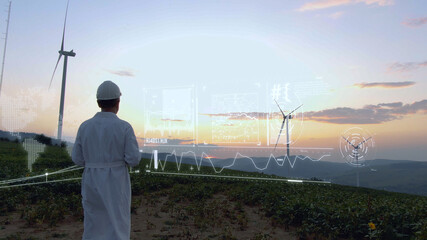 Worker in white uniform working on wind farm on sunset using futuristic technology with 3d model construction of windmill buildings. Agronomy business. Tech innovation. Hi-tech concept. Human future.
