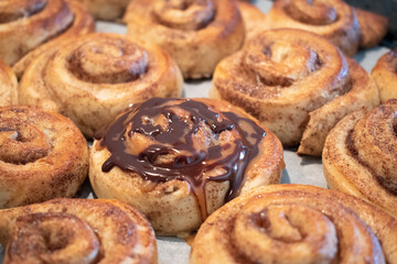 Beautiful homemade cinnamon rolls freshly baked. Some chocolate and caramel to add some sweet to a already very caloric sweet snack.