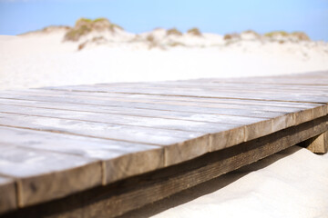 Wooden walkway to a beach. Wooden path on the sand dunes near a sea or ocean. Selective focus. Vacation concept.