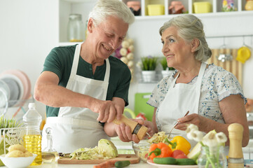 Senior couple cooking together at kitchen
