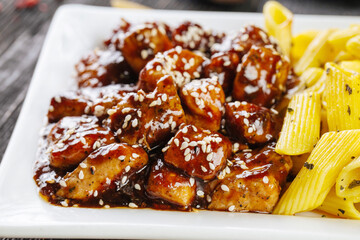 Closeup on asian fried chicken with sesame seeds and pasta