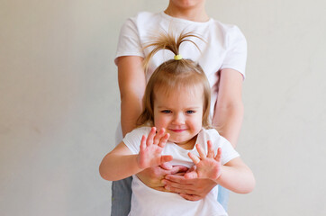 Big brother hands holding cute toddler sister at home. Child in white t-shirt playing, having fun,...