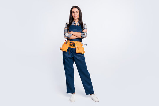 Full size photo of serious woman builder engineer with folded hands wear blue overall isolated on white color background
