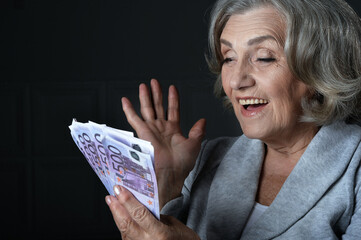 Happy  elderly woman with euros