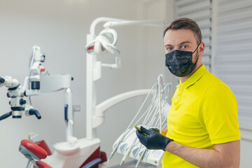 Fototapeta na wymiar Close up portrait of a confident dentist in a medical office or clinic. Attractive bearded young man, modern male doctor or friendly medic in the workplace. looking at the camera in hospital. closeup