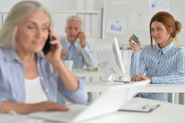 Fototapeta premium Businesspeople working in modern light office. businesswoman talking on the smartphone