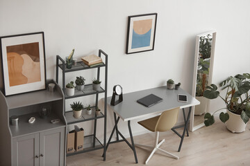 High angle background of minimal home office workplace in modern apartment decorated by plants and abstract art, copy space