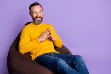 Profile side photo of mature man happy positive smile sit bean chair look empty space isolated over violet color background