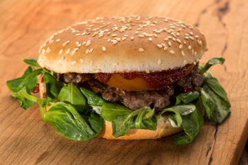 Panino con hamburger pomodoro , insalata e patatine sopra un tavolo di legno