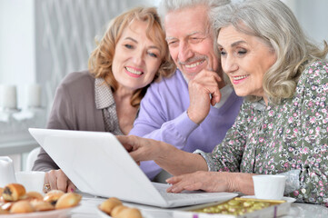 senior people with laptop drinking tea