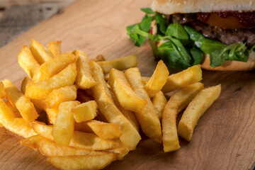 patatine fritte su un tavolo di legno vicino ad un hamburger