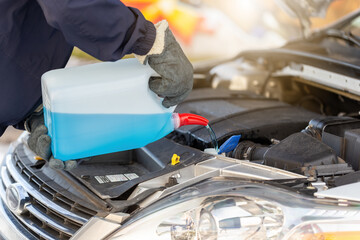 Person pouring antifreeze to the car in wintertime