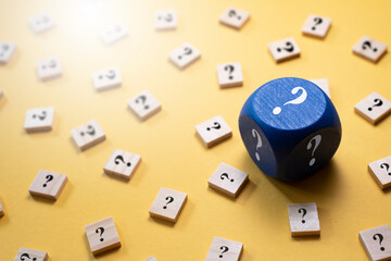 Question Mark on a dice and wooden alphabet tiles against yellow background. Concept of Choice,FAQ,...
