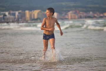 child swims in the sea waves on the beach