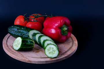 On a wooden chopping board, vegetables for salad.