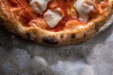 Pizza tonda al pomodoro sopra una telia di metallo