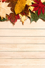 Naklejka na ściany i meble Autumn leaves on brown wooden background