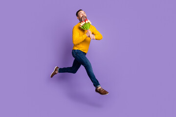 Fototapeta na wymiar Profile photo of dreamy man jump run hold bunch flowers wear yellow sweater jeans shoes isolated violet background