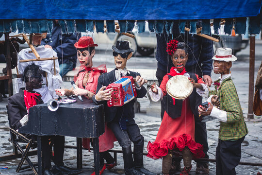View of street puppet show theatre, with puppeteer puppet master pulling the strings over marionette dolls